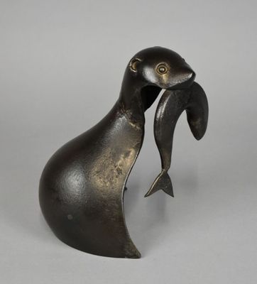 une statue en bronze représentant un oiseau tenant un poisson dans son bec