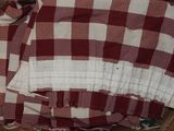 une chemise à carreaux marron et blancs dans une boîte marron