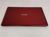 the back of a red laptop computer sitting on top of a white surface