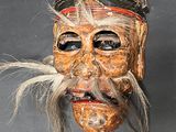 a wooden mask with a long beard and a hat on it