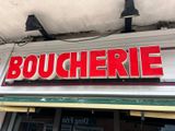 a red sign that says boucherrie on the side of a building