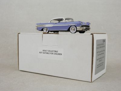 une petite voiture bleue et blanche posée sur une boîte