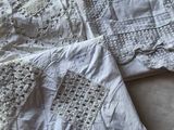 une nappe blanche ornée de crochets et de dentelles