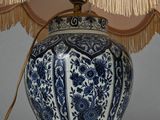 a blue and white lamp with a beige shade on it