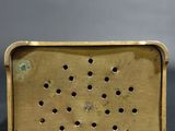 a close up of a brass cigarette case with holes in it