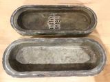 two empty metal containers sitting on a wooden table