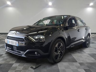 la voiture noire est garée sur un sol en damier dans le garage