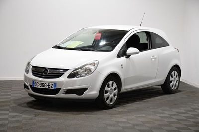 the small white car is parked in a room with a checkered floor