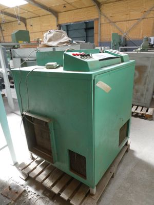 a green machine that is sitting on a pallet in a warehouse