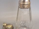 a glass salt and pepper shaker with a bird figurine next to it