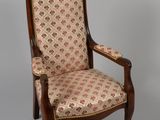 an antique chair with a floral upholstered back and arms