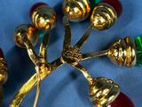 a gold brooch with red, green, and yellow beads