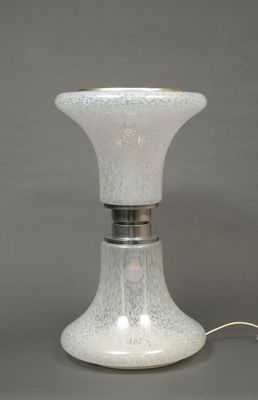 a white glass lamp that is on a table
