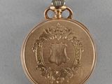 an image of a gold pocket watch with a picture of an eagle on it
