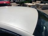 a white car parked in a parking lot with other cars
