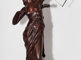 une statue antique en bronze représentant une femme avec un arc et des flèches