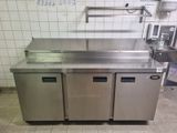 a stainless steel counter with three doors in a commercial kitchen
