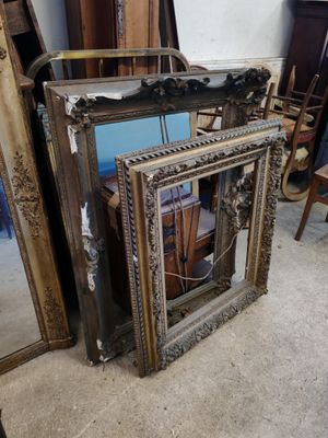 deux miroirs et une chaise dans un coin de la pièce