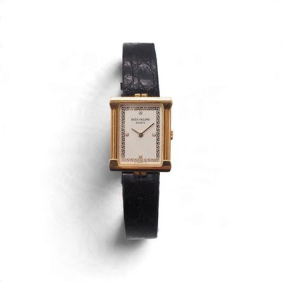 un gros plan d'une montre sur une surface blanche avec un fond blanc