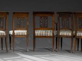 four wooden chairs with upholstered seats in a row