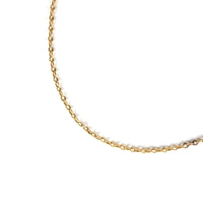 gros plan d'un bracelet en chaîne en or sur fond blanc