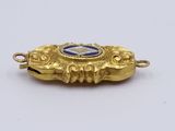 an image of a gold pendant with a blue stone in the center