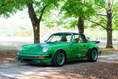 a green car that is parked on the side of the road