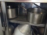 pots and pans sitting on a shelf in a kitchen
