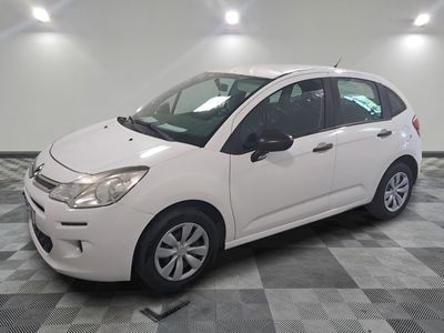 the small white car is parked on a checkered tile floor