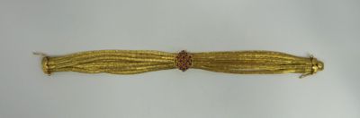 an image of a close up of a gold bracelet on a white surface