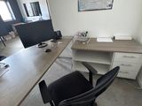 a desk with a computer and a chair in the room