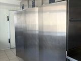stainless steel refrigerators in a commercial kitchen with tile flooring