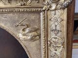 a gold frame with a painting of a man and a dog