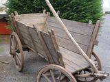 a small wooden cart with a wooden handle on the street