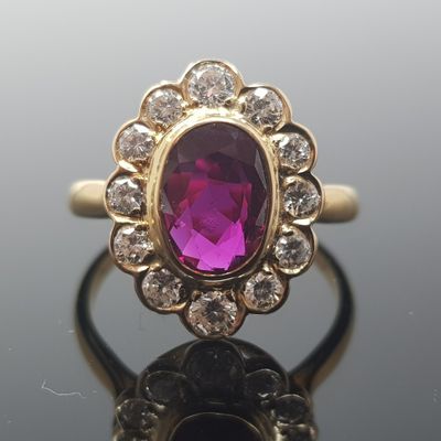 une image représentant une bague ornée d'une pierre violette entourée de diamants