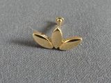 a close up of a gold earring on a gray surface