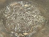 a large metal bowl with writing on it