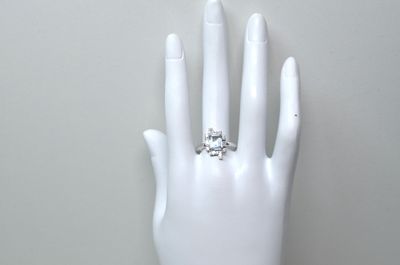une main portant une bague, posée sur un mannequin