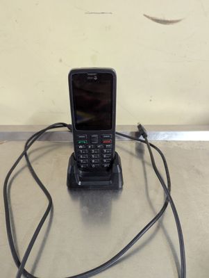 un téléphone portable branché à un chargeur posé sur une table