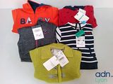 three sweaters and a cardigan on a white table
