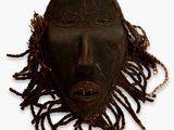 une image représentant un masque en bois avec des dreadlocks sur fond blanc