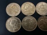 six different coins are shown on a black surface