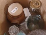 a cardboard box filled with items that include jars and jars