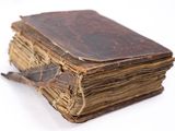 an old book sitting on top of a white table