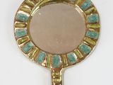 un miroir doré orné d'un motif vert