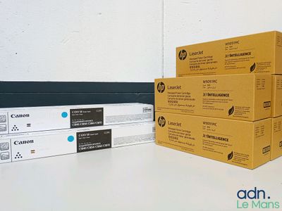 trois boîtes de cartouches de toner noir et blanc posées sur une table