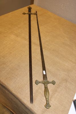 deux épées posées sur une boîte, elle-même posée sur une table