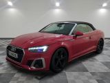 a red audi convertible parked on a checkered tile floor