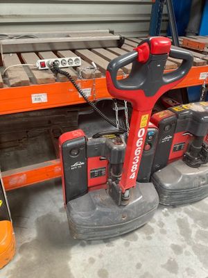 a red and black machine that is sitting in a warehouse