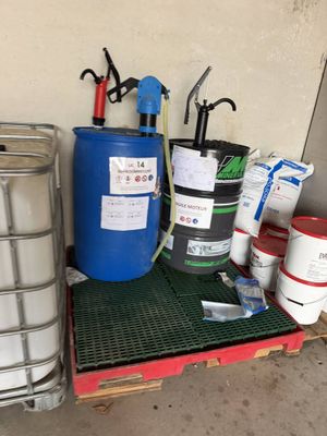 un conteneur métallique et un fût bleu posés sur une palette